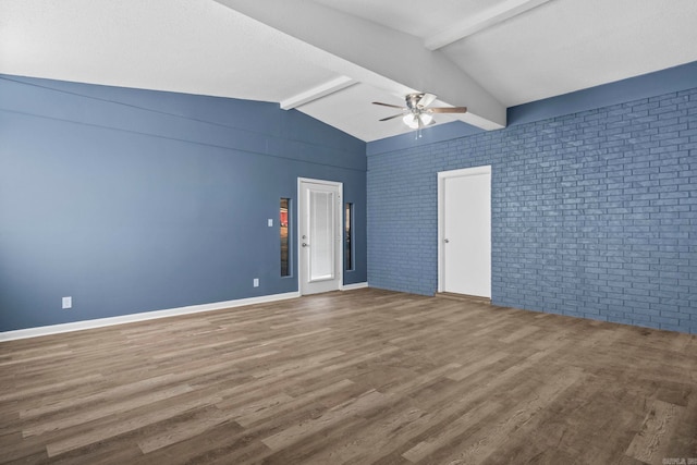 empty room with ceiling fan, vaulted ceiling with beams, brick wall, wood finished floors, and baseboards