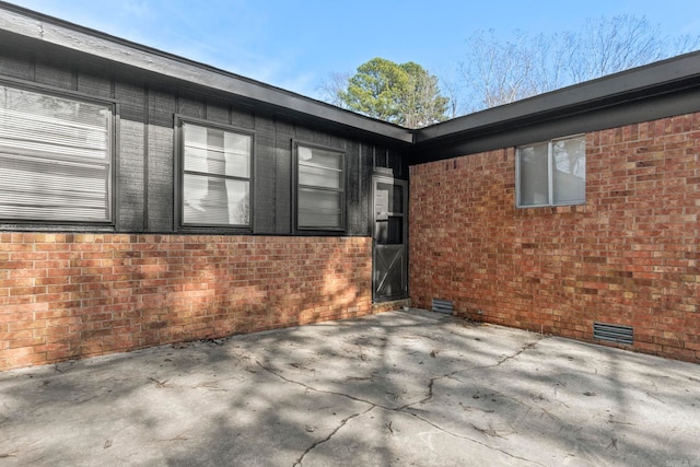 exterior space featuring crawl space, a patio, and brick siding