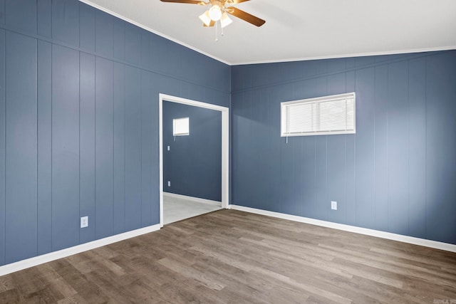 unfurnished room with baseboards, crown molding, a ceiling fan, and wood finished floors