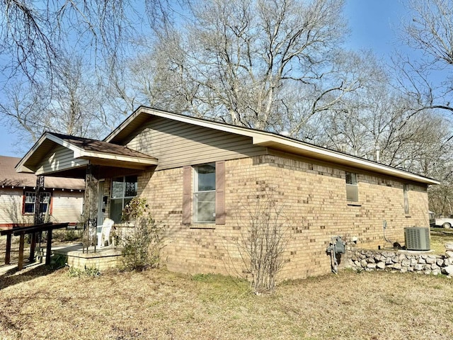 view of side of home featuring a patio area, cooling unit, and brick siding