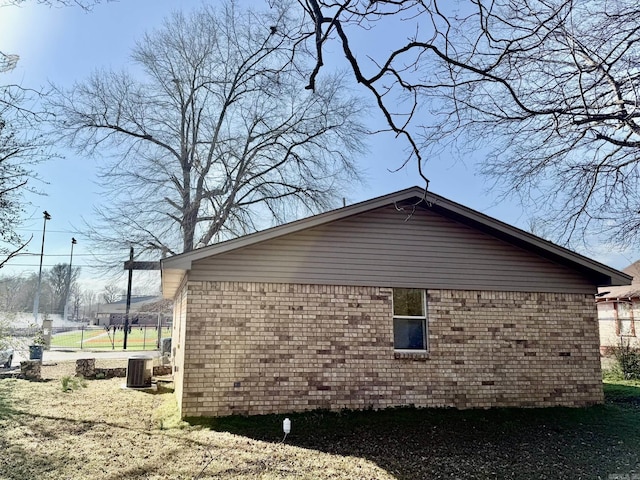 view of property exterior featuring brick siding and central AC unit