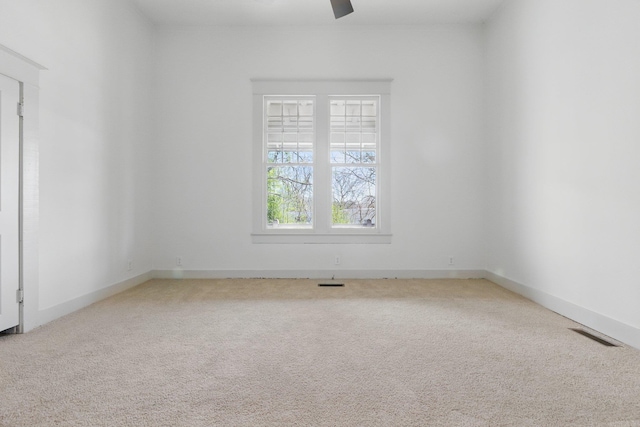 unfurnished room with baseboards, carpet floors, visible vents, and a ceiling fan