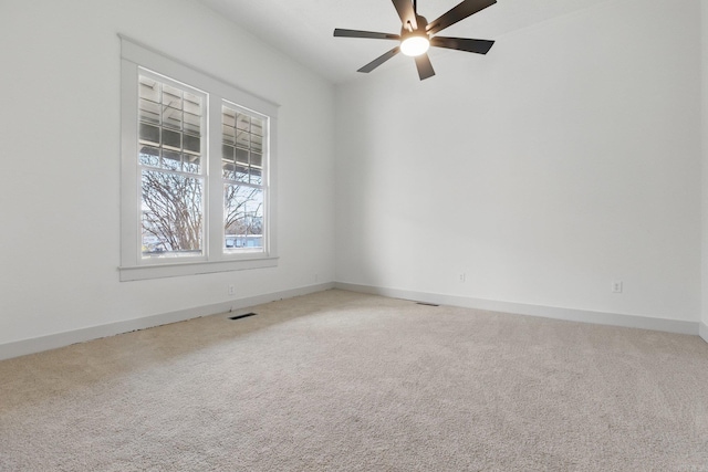 empty room with ceiling fan, visible vents, baseboards, and carpet flooring