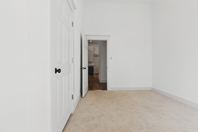 unfurnished room with baseboards and light colored carpet