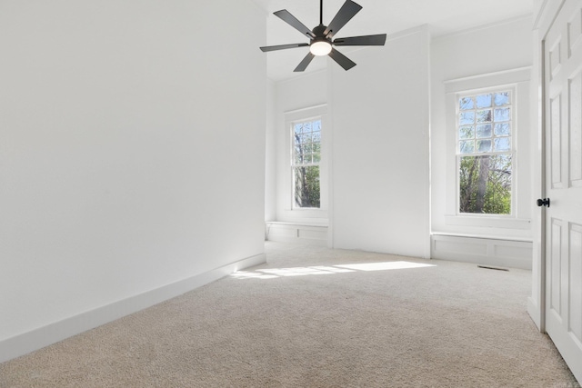 carpeted empty room with ceiling fan and visible vents