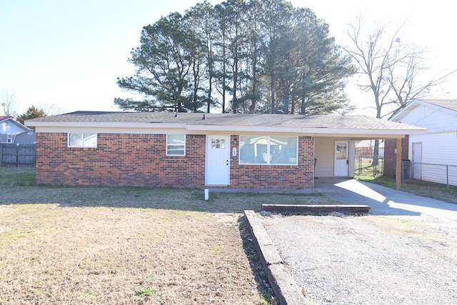 ranch-style home with concrete driveway, brick siding, fence, and an attached carport