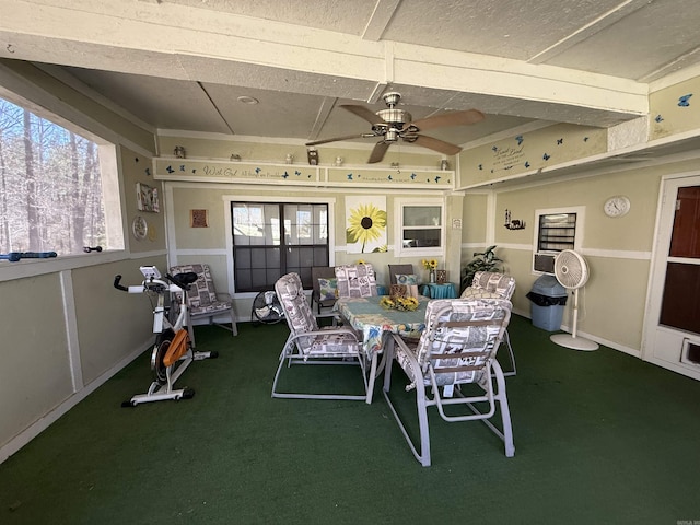 carpeted dining room with a ceiling fan and baseboards