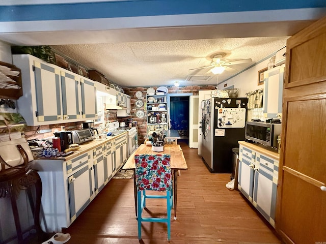 kitchen featuring ceiling fan, appliances with stainless steel finishes, a textured ceiling, and wood finished floors