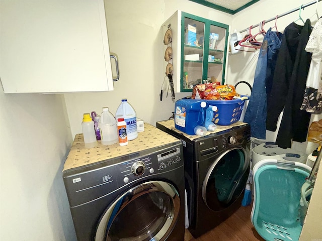 laundry room featuring wood finished floors, washing machine and clothes dryer, and cabinet space