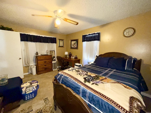 carpeted bedroom with ceiling fan and a textured ceiling