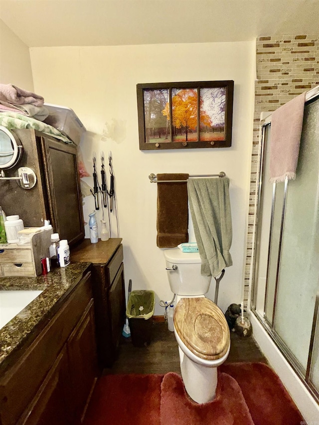 full bathroom featuring a stall shower, vanity, and toilet