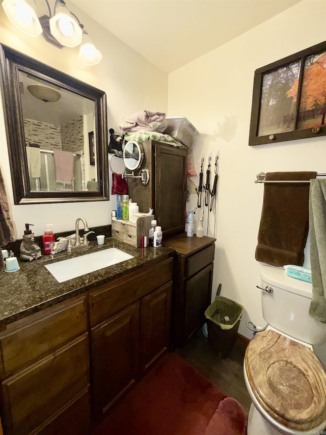 bathroom with toilet, a shower stall, and vanity