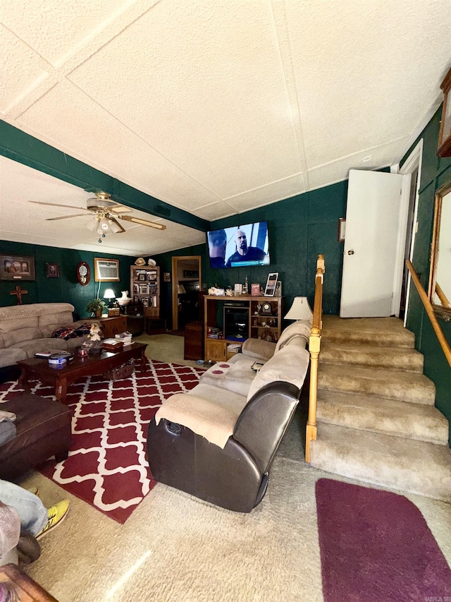 living room featuring ceiling fan and stairs