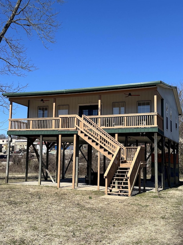 rear view of property with stairs and ceiling fan