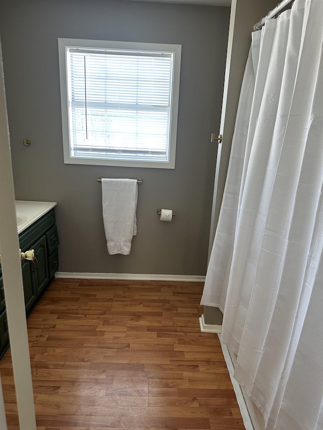 bathroom with vanity, baseboards, and wood finished floors