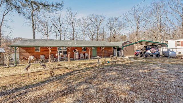 view of front of house with a porch, a carport, and dirt driveway