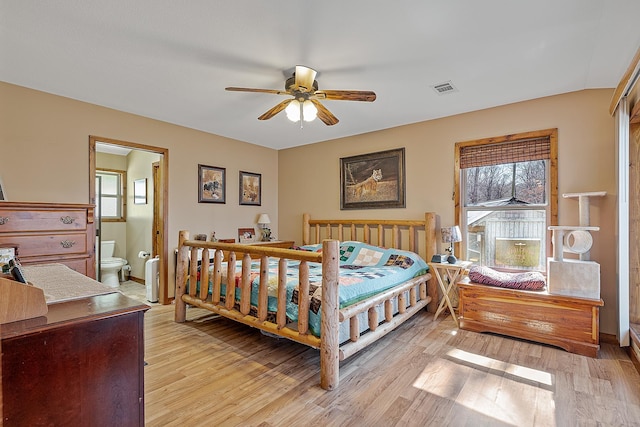 bedroom featuring connected bathroom, visible vents, baseboards, a ceiling fan, and light wood finished floors