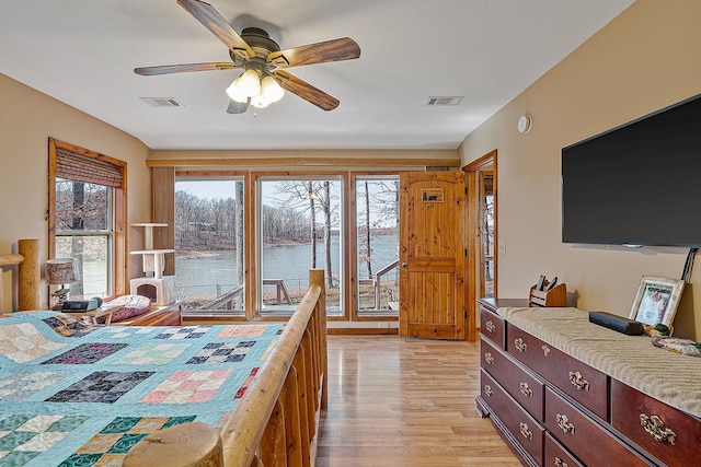 bedroom with light wood finished floors, ceiling fan, and visible vents