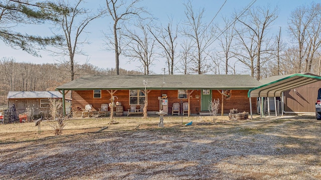 view of front of house with a carport, covered porch, and driveway