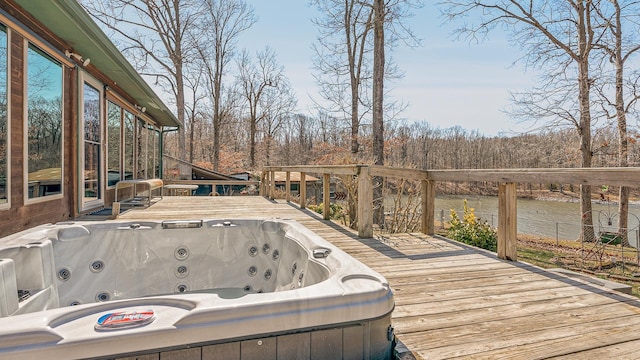 wooden terrace with a water view and a hot tub