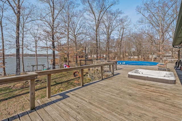 wooden deck with a fenced in pool and a water view