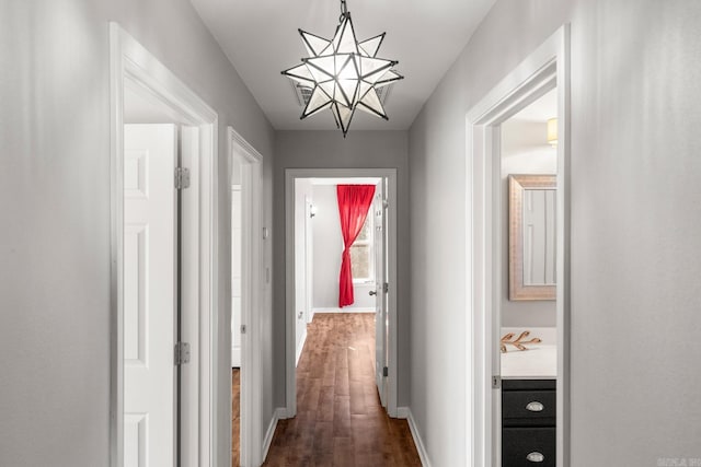 corridor featuring dark wood finished floors and baseboards