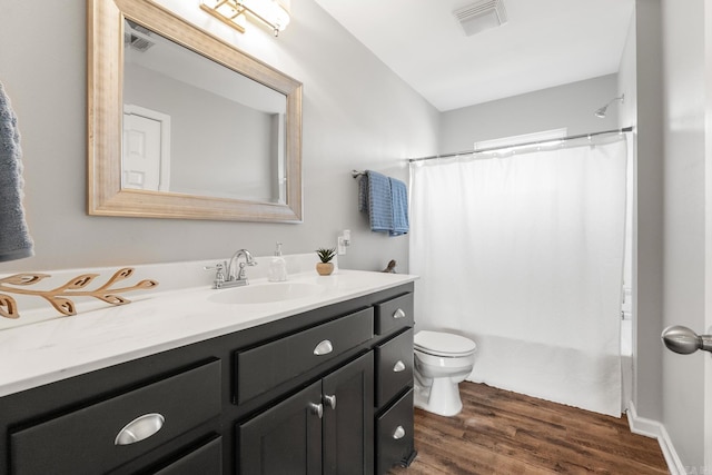 bathroom with visible vents, vanity, toilet, and wood finished floors