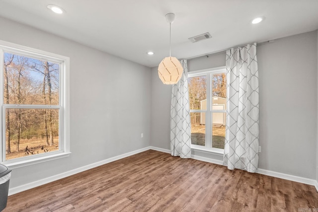 unfurnished dining area featuring recessed lighting, visible vents, baseboards, and wood finished floors