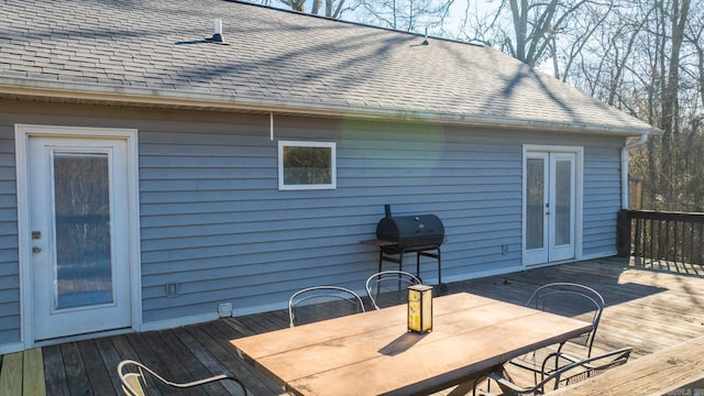 wooden deck featuring outdoor dining area and french doors