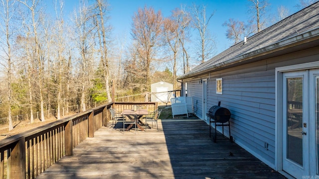 deck with an outbuilding, a shed, and grilling area