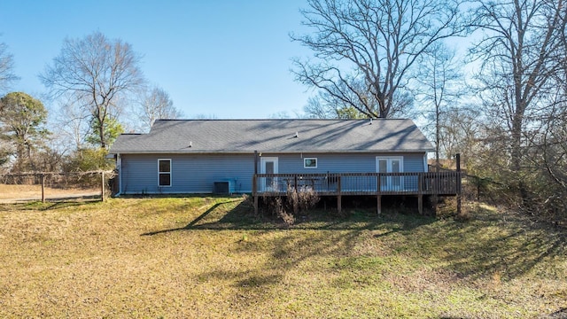 rear view of property with central air condition unit, a yard, a deck, and fence