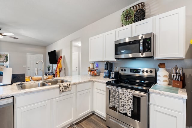 kitchen with ceiling fan, a sink, white cabinets, appliances with stainless steel finishes, and dark wood-style floors