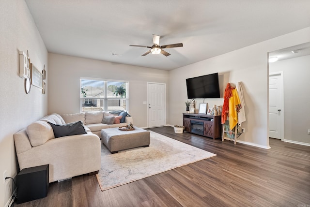 living room featuring ceiling fan, baseboards, and dark wood finished floors