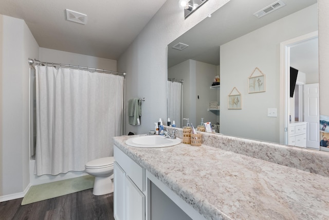 full bathroom featuring toilet, vanity, wood finished floors, and visible vents