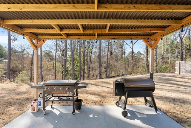 view of patio with a wooded view and a grill