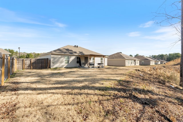 rear view of house featuring a yard, a patio area, and a fenced backyard