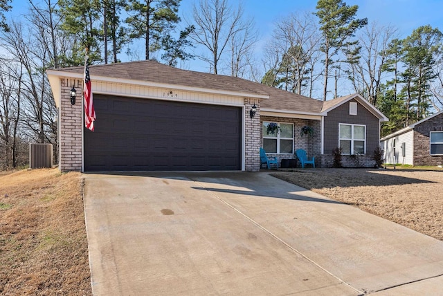 ranch-style house featuring a garage, concrete driveway, and central AC