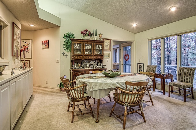 dining room with light carpet, vaulted ceiling, and a textured ceiling