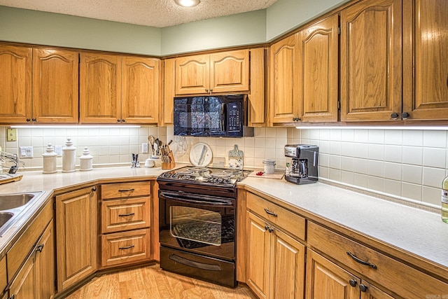 kitchen featuring black appliances, brown cabinets, and light countertops