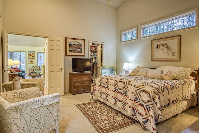 carpeted bedroom featuring a high ceiling