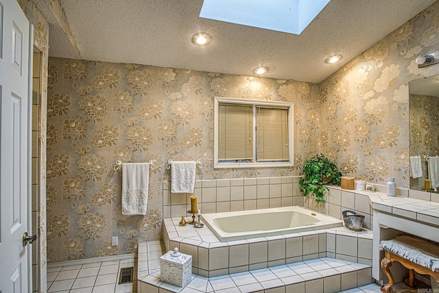 full bath with wallpapered walls, a skylight, tile patterned floors, a garden tub, and a textured ceiling