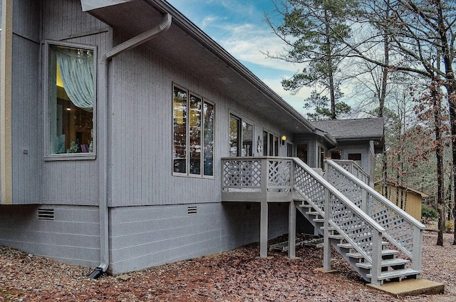 view of side of property featuring crawl space, a deck, and stairs