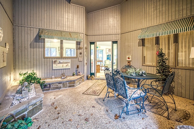 dining room featuring wood walls and carpet