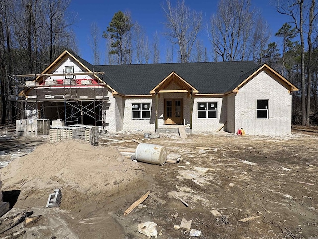 unfinished property with a wooden deck and brick siding