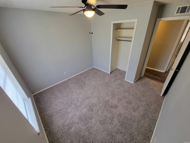 unfurnished bedroom with ceiling fan, carpet flooring, visible vents, baseboards, and a closet