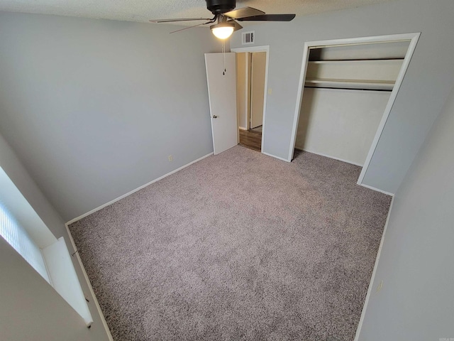 unfurnished bedroom with carpet floors, a ceiling fan, visible vents, and a closet