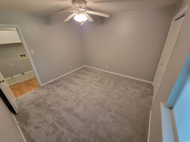 unfurnished bedroom with a ceiling fan, carpet, and baseboards