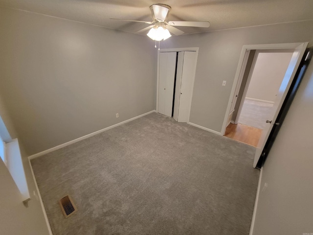 unfurnished bedroom with a ceiling fan, carpet, baseboards, and a closet