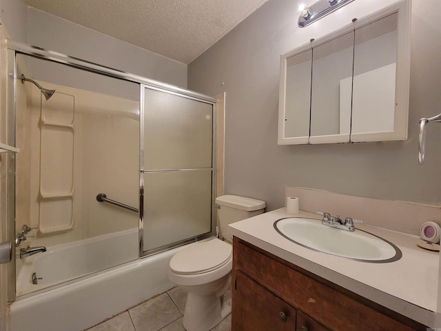 full bath with a textured ceiling, tile patterned flooring, toilet, bath / shower combo with glass door, and vanity