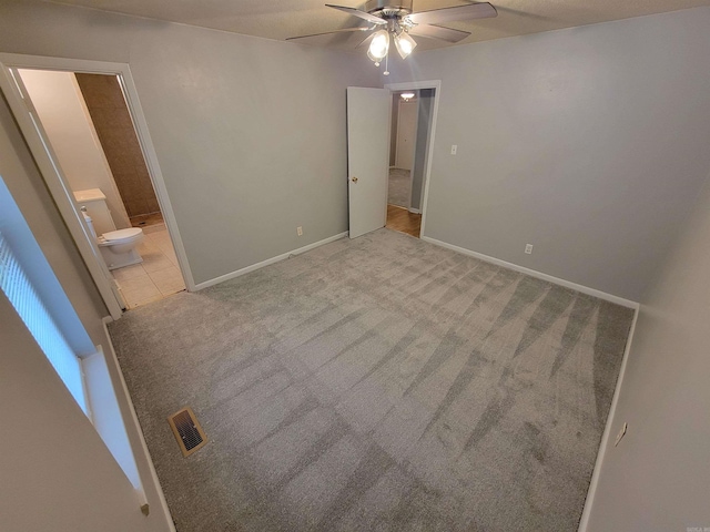 unfurnished bedroom with carpet floors, visible vents, connected bathroom, and baseboards